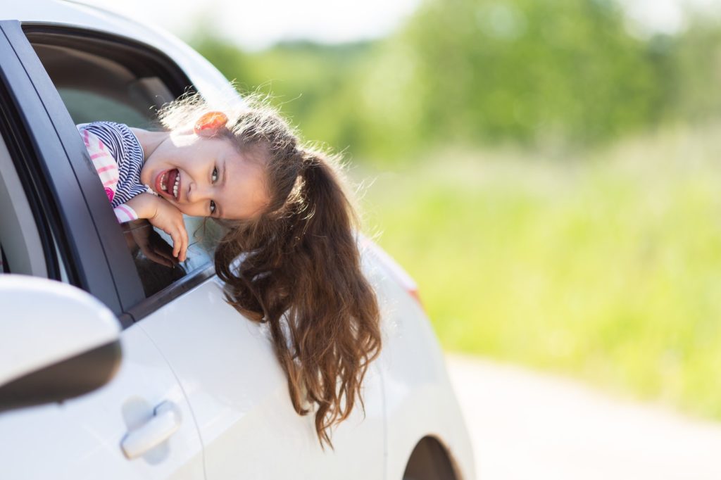 little girl in back of car after a family day out